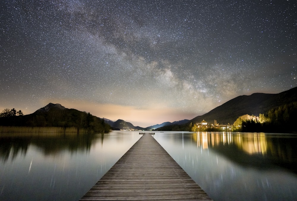 brown wooden dock on lake during night time