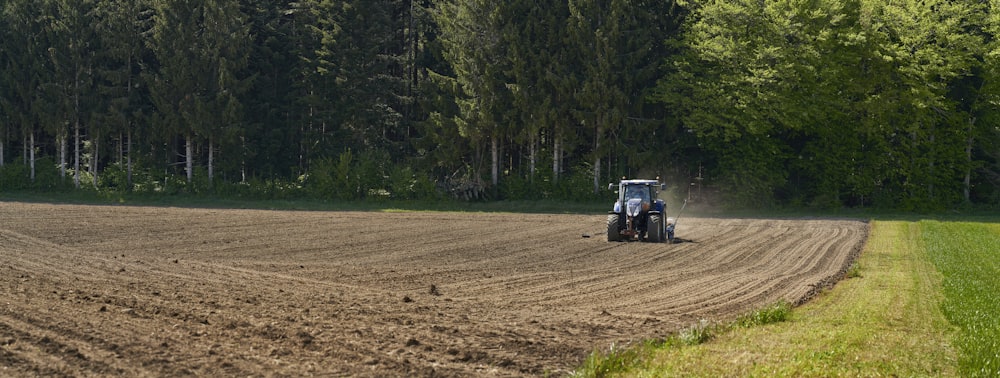 Tractor azul en campo marrón durante el día