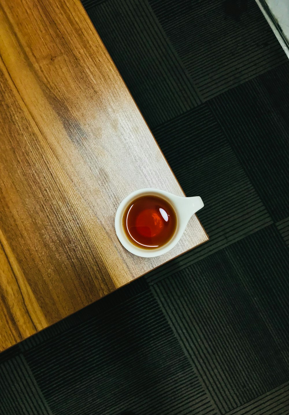 orange and white ceramic mug on brown wooden table