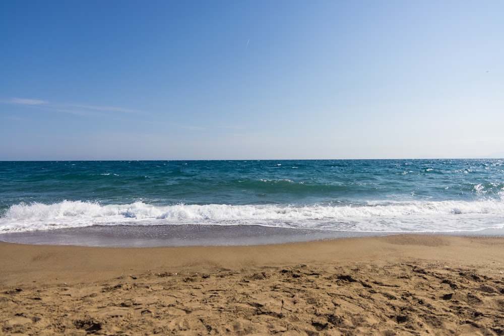 sea waves crashing on shore during daytime