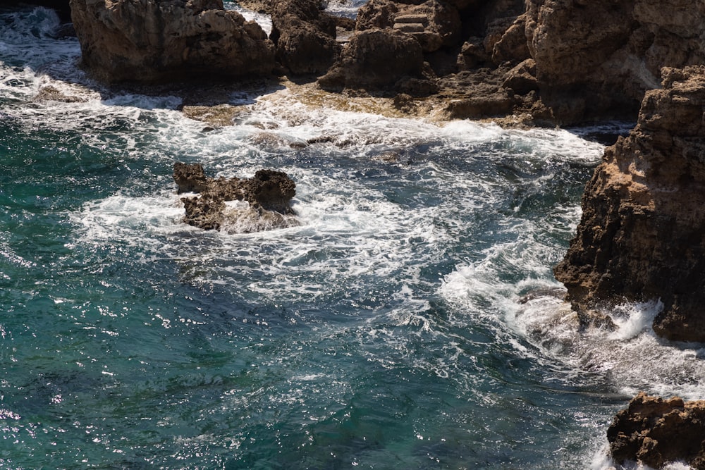 brown rock formation on body of water during daytime