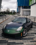 A sleek customized car with a glossy black finish parked in an urban setting.