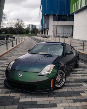 A sleek customized car with a glossy black finish parked in an urban setting.