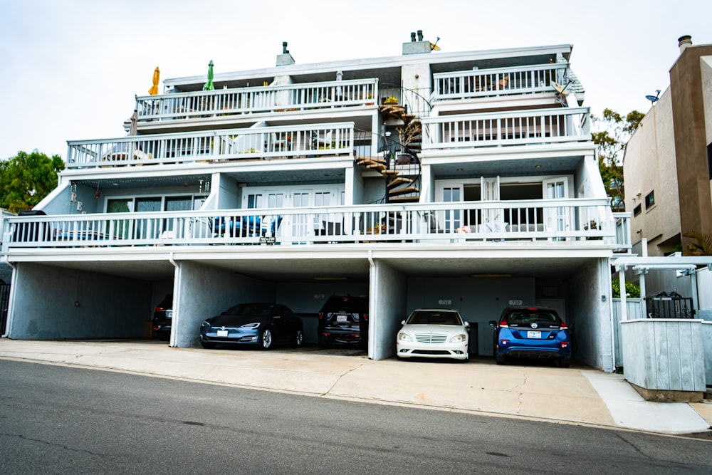 Edificio in calcestruzzo bianco con auto blu su strada durante il giorno