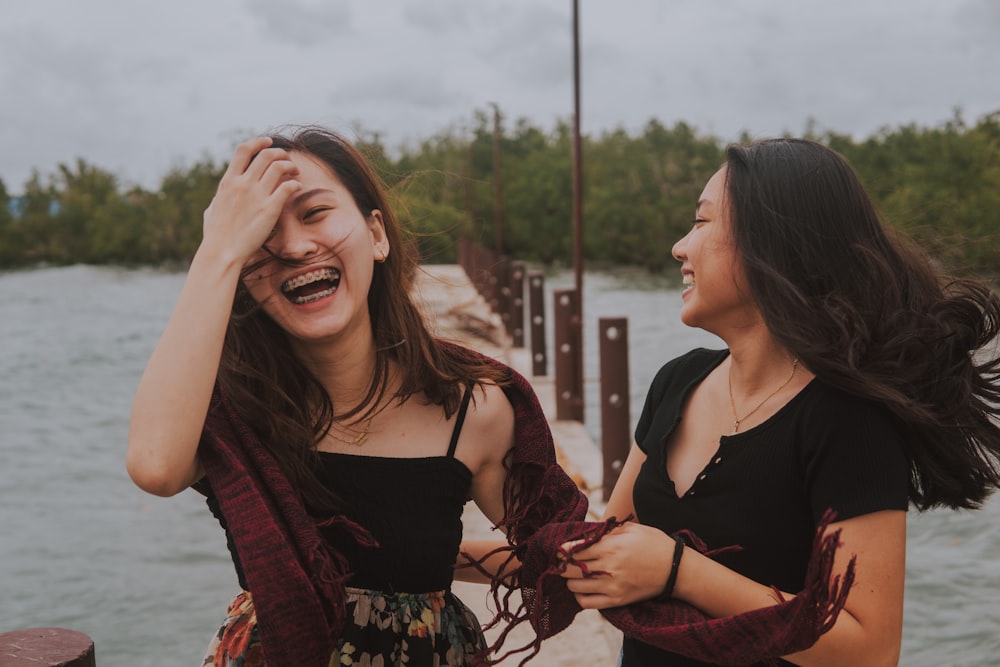 woman in black tank top and red cardigan smiling