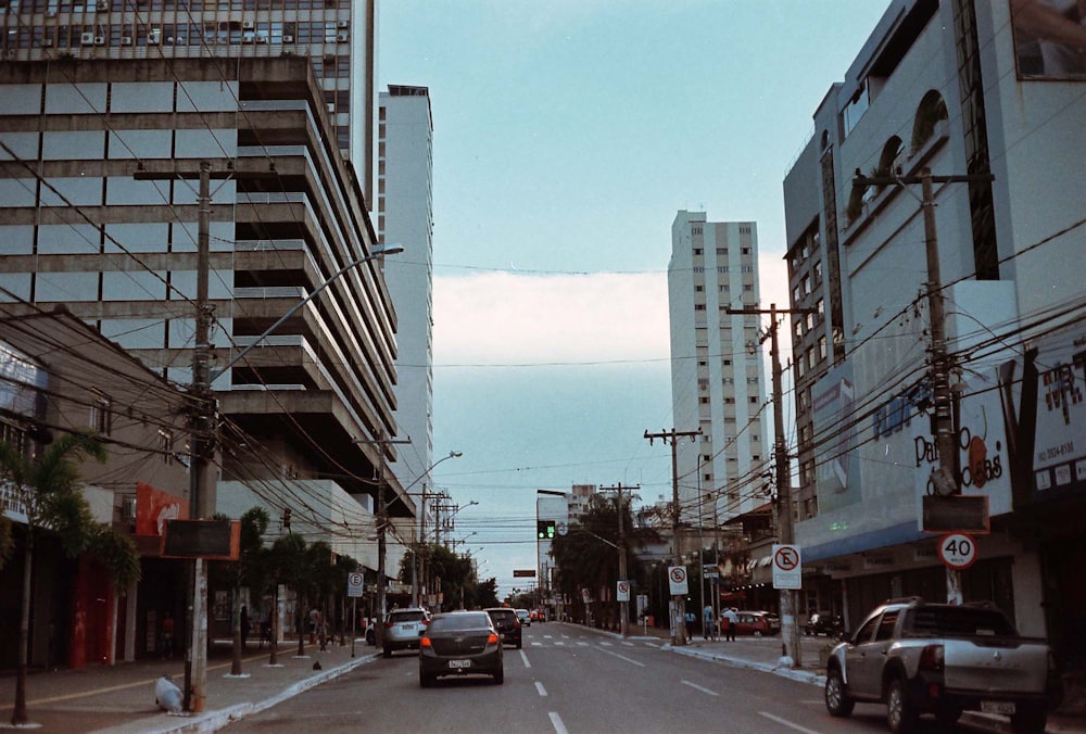 cars on road between buildings during daytime