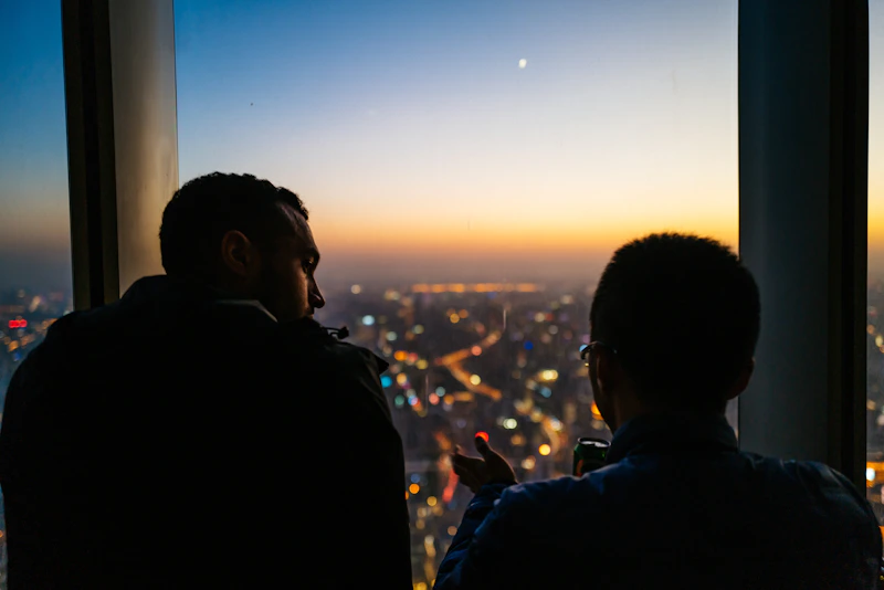 confident man in a black jacket at sunset
