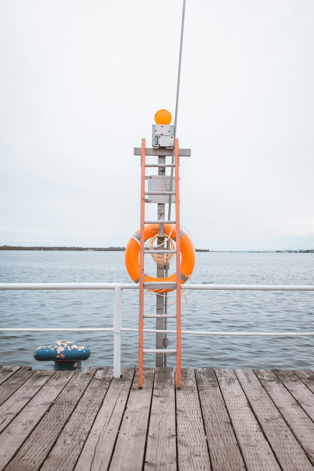 orange-weißer Rettungsschwimmerturm in der Nähe des Gewässers tagsüber