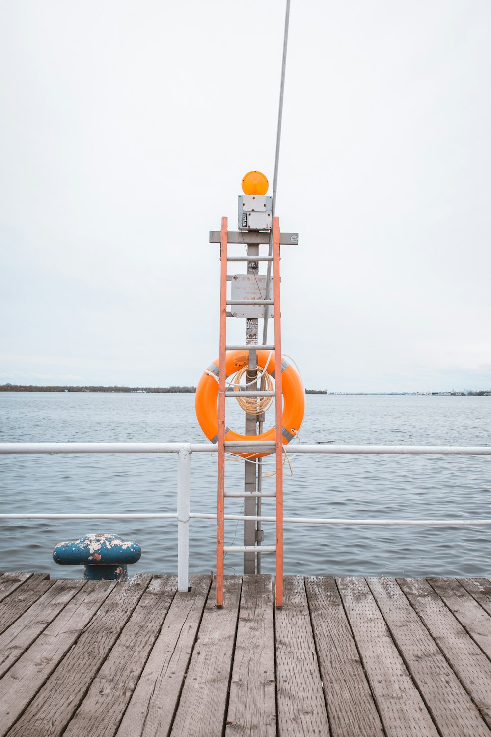 orange and white lifeguard tower near body of water during daytime