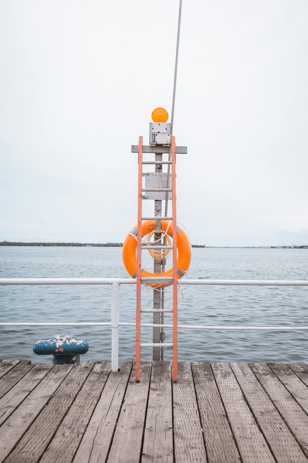 orange and white lifeguard tower near body of water during daytime