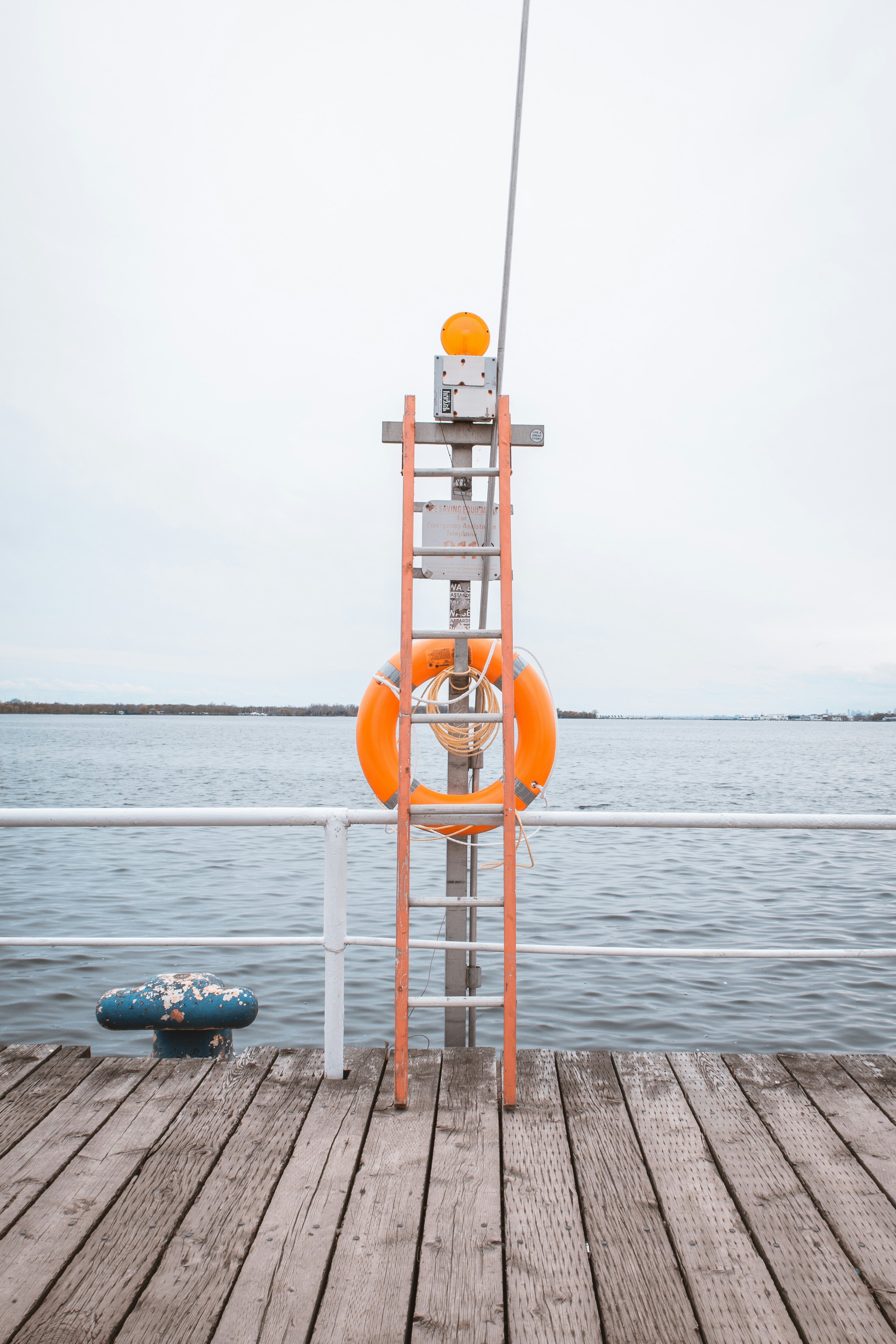orange and white lifeguard tower near body of water during daytime