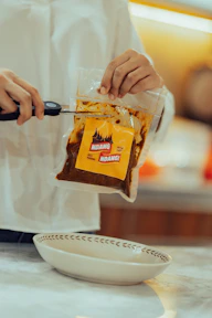 person holding yellow and brown plastic pack