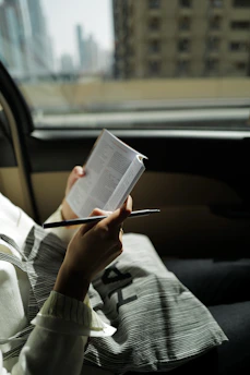 person in gray and black long sleeve shirt reading book