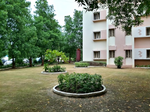 green grass field near white concrete building during daytime