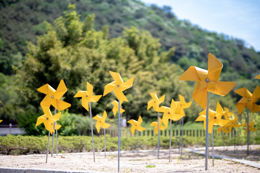 a row of yellow pinwheels sitting next to each other
