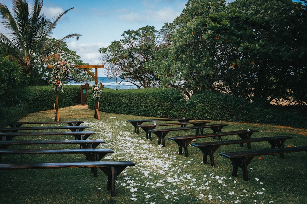 brown wooden picnic table on green grass field during daytime