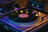 Close-up of a DJ spinning vinyl records at night.