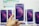 A hand is holding a boxed smartphone with a stylized purple and pink circle design on the front. Multiple identical smartphone boxes are displayed in the background.