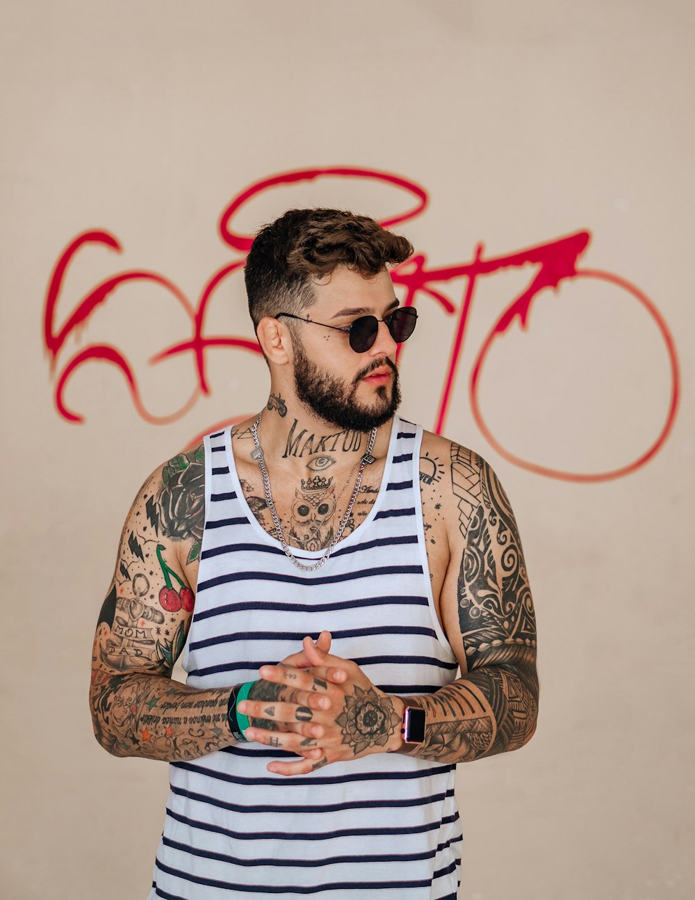 Mann in weiß und braun gestreiftem Tanktop mit Sonnenbrille