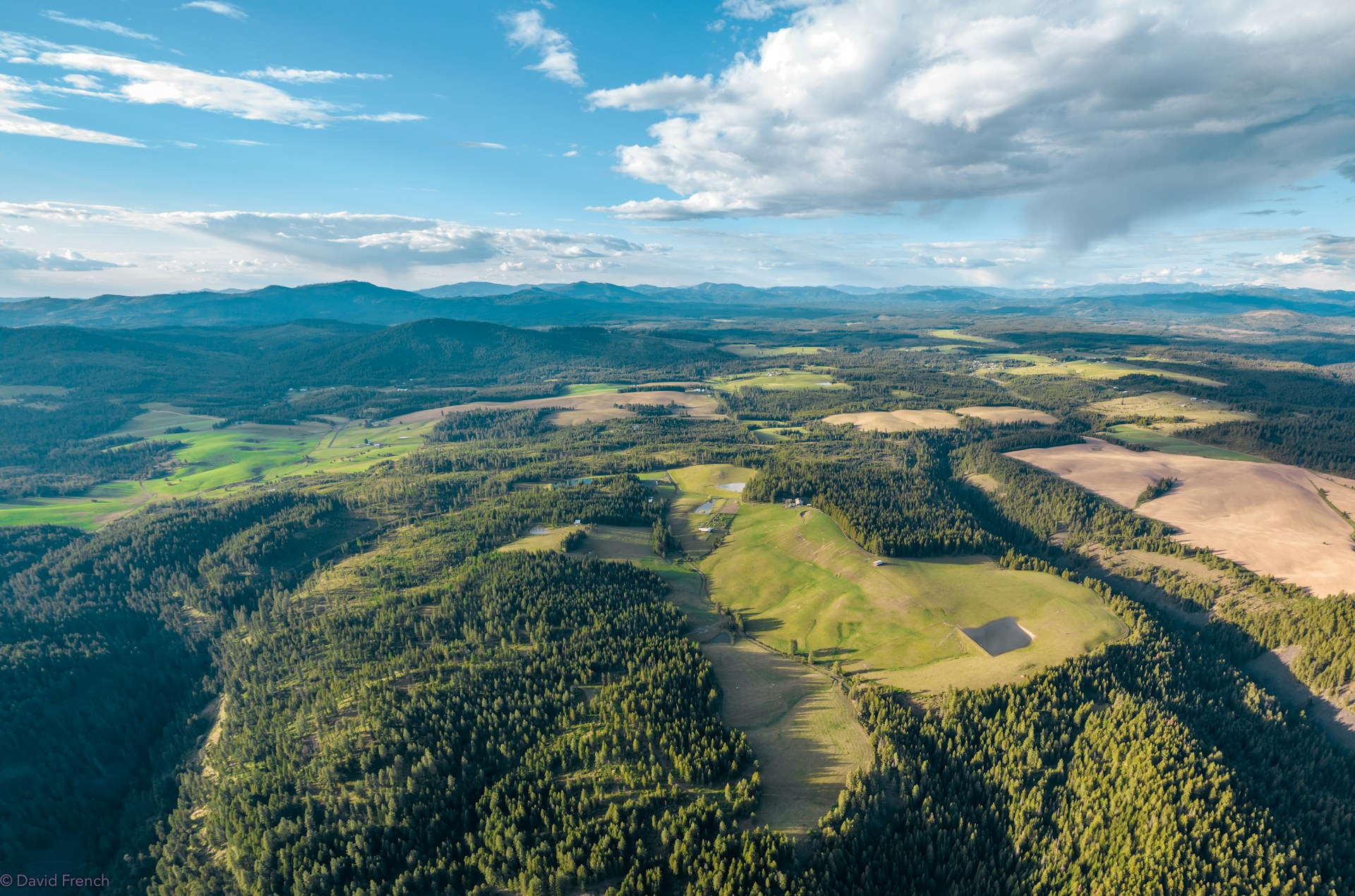 Aerial shot of a diverse landscape with forests, fields, and waterways, illustrating the variety of properties Keystone Land Co. manages.