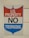 A sign with a red, white, and blue shield design displays the words 'U.S. Property No Trespassing' in bold letters. It is mounted on a light-colored wooden wall.