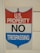 A sign with a red, white, and blue shield design displays the words 'U.S. Property No Trespassing' in bold letters. It is mounted on a light-colored wooden wall.
