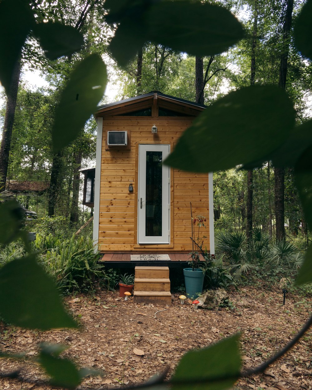 brown wooden house near green trees during daytime