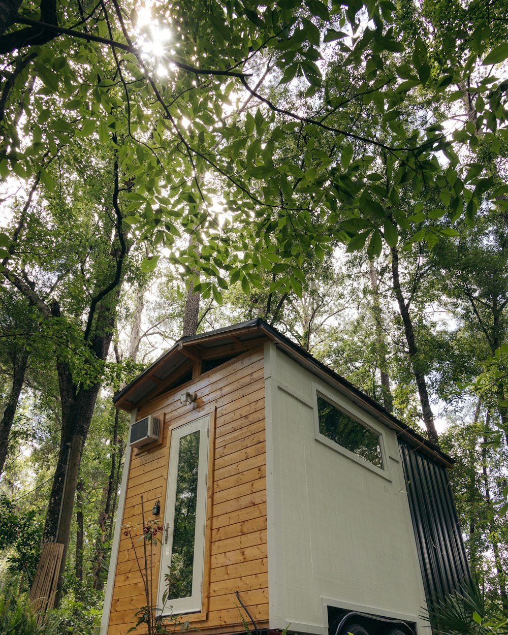 Maison blanche et brune près d’arbres verts pendant la journée