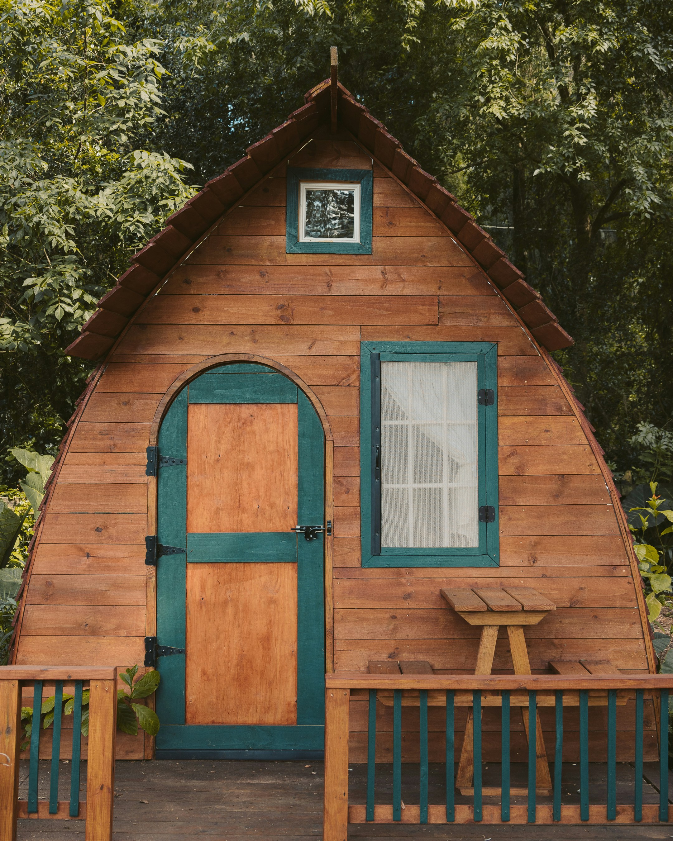 brown wooden house near green trees during daytime