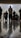 A group of people are standing in a room, viewed from a low angle that emphasizes the reflective flooring. The individuals appear engaged in an activity, possibly a prayer or meditation session, based on their posture. The room is softly lit, adding a serene atmosphere.