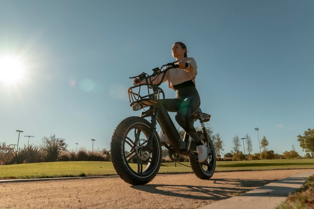 woman in black tank top and green shorts riding black motorcycle during daytime