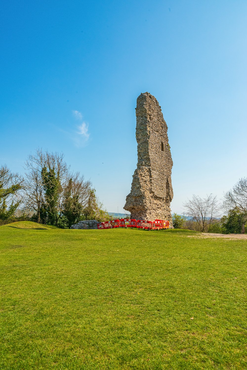 brown rock formation on green grass field under blue sky during daytime