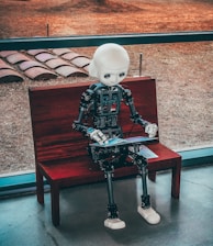 black and white robot toy on red wooden table