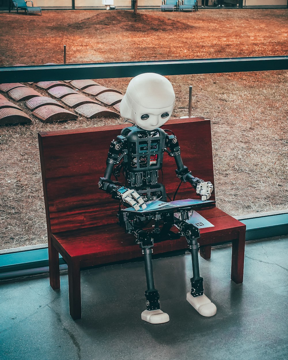 Robot sitting on a bench, using AI video editing tools on a tablet