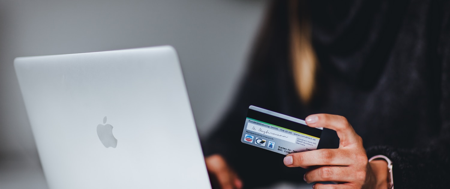 woman holding black smartphone near silver macbook