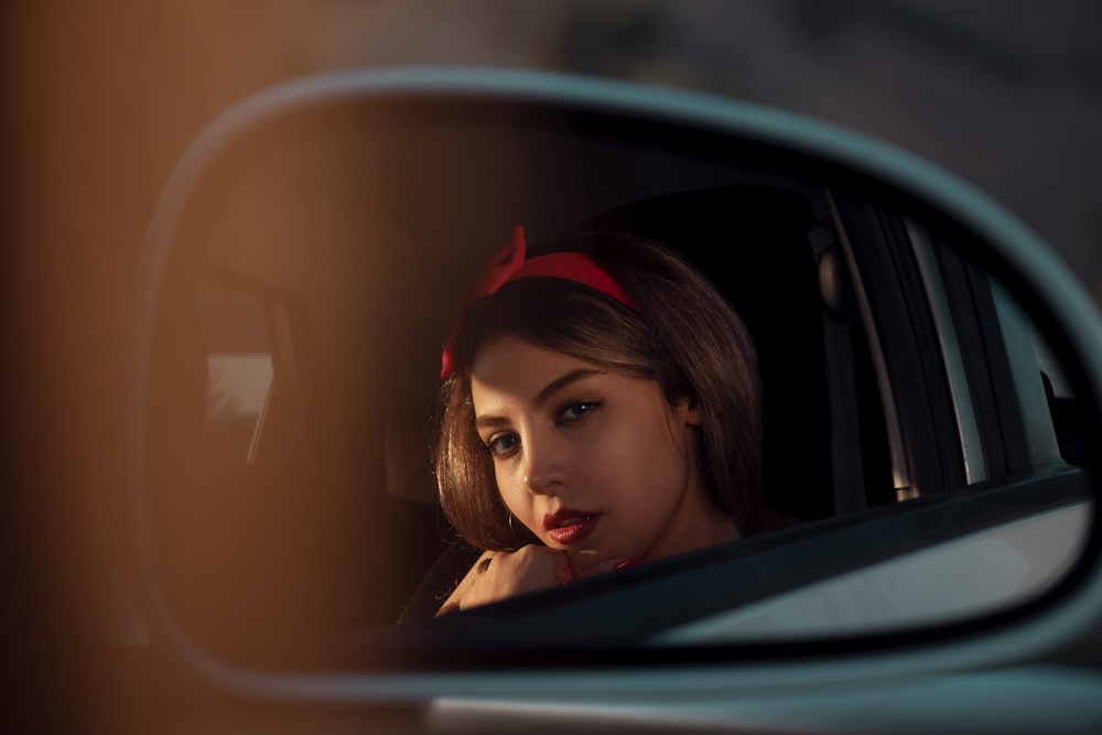 woman in car side mirror