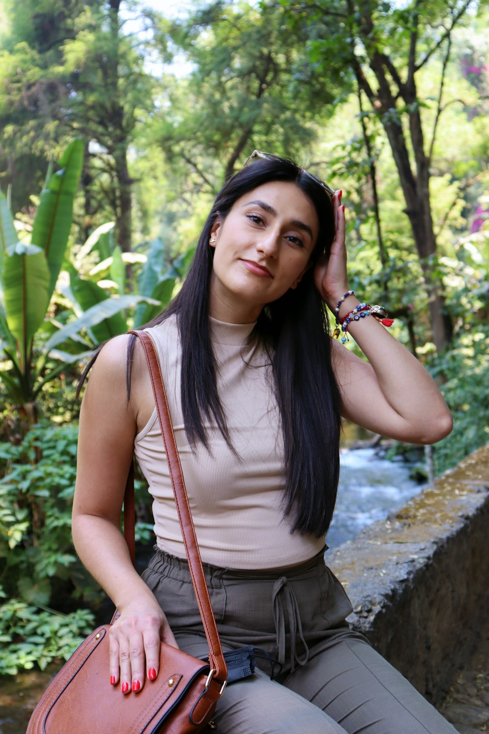 Mujer con camiseta gris sin mangas y pantalones cortos grises de pie cerca de Green Leaf Tree durante el día