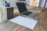Detail of a wooden desk with a notebook and pen, ready for client notes.
