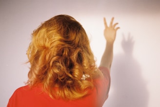 woman in red shirt holding her hair