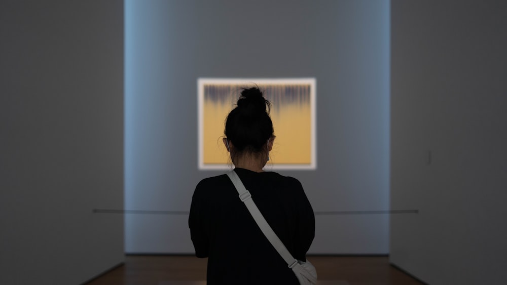 woman in black long sleeve shirt standing in front of white wall