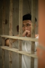 man in white shirt in white metal cage