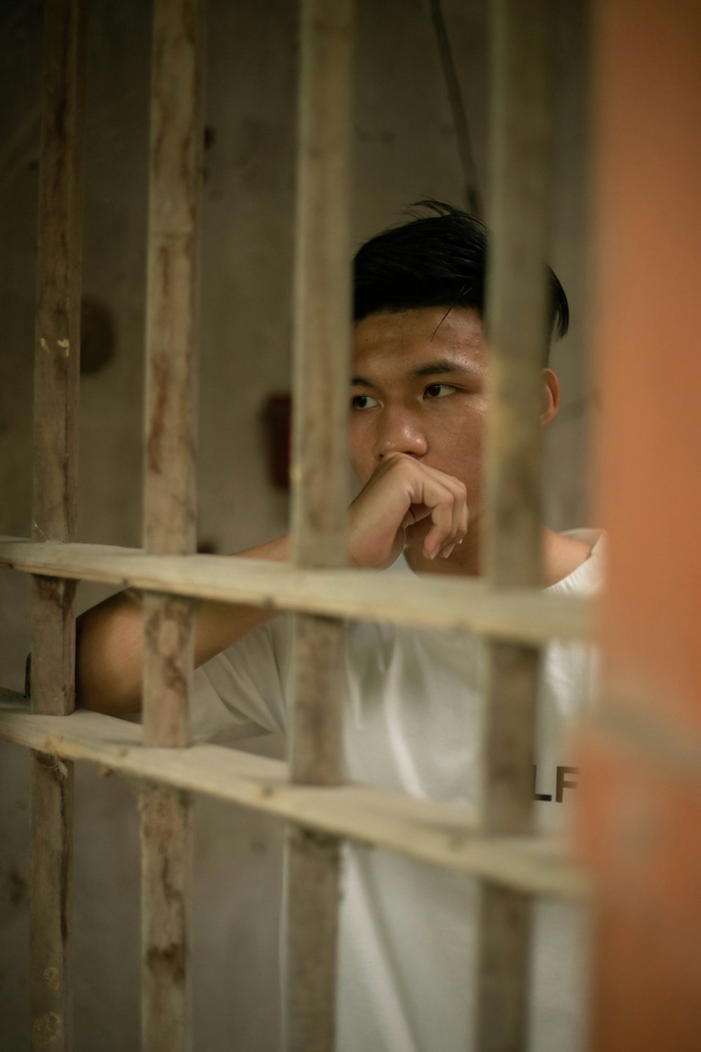 man in white shirt in white metal cage