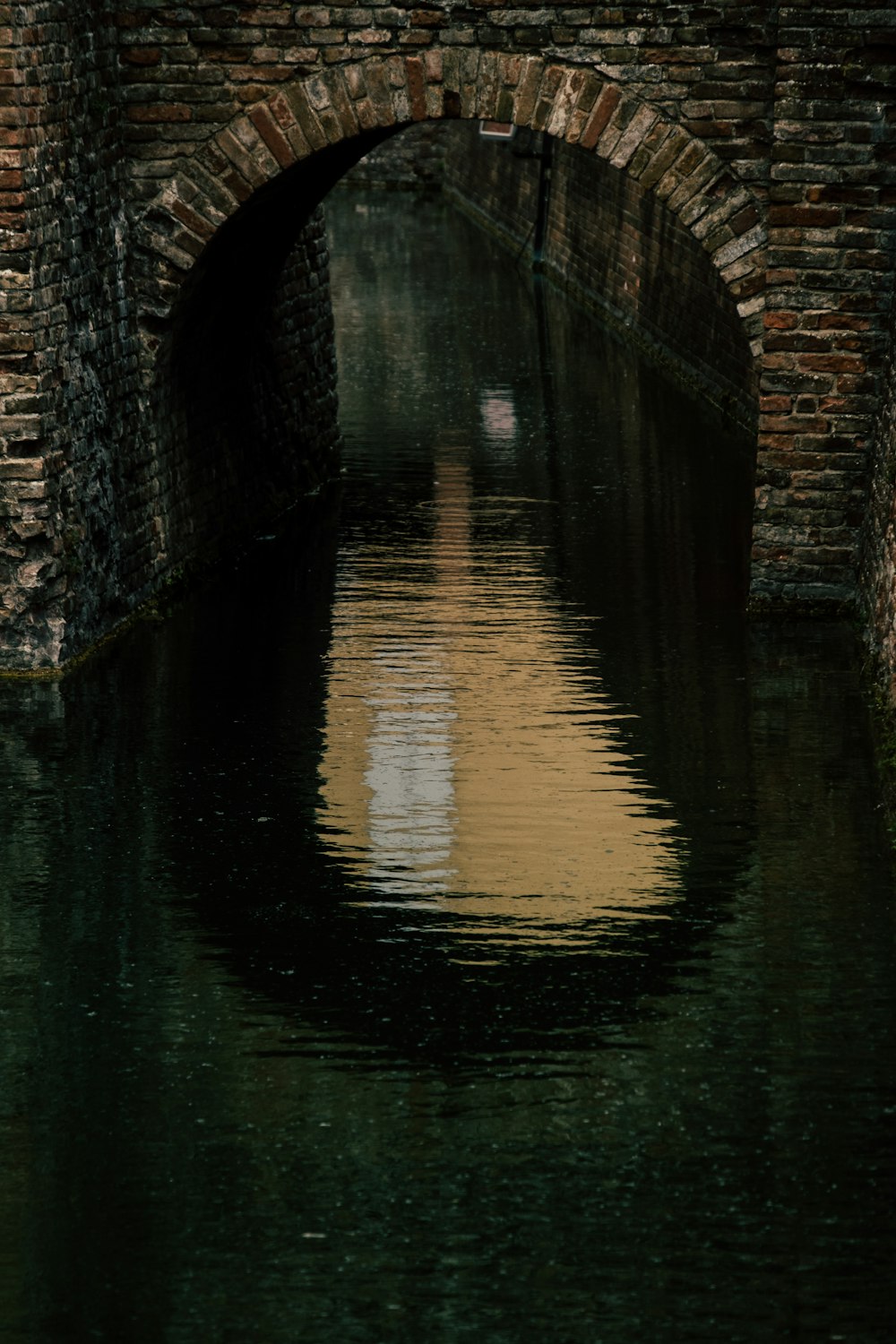 reflection of gray concrete bridge on water during daytime