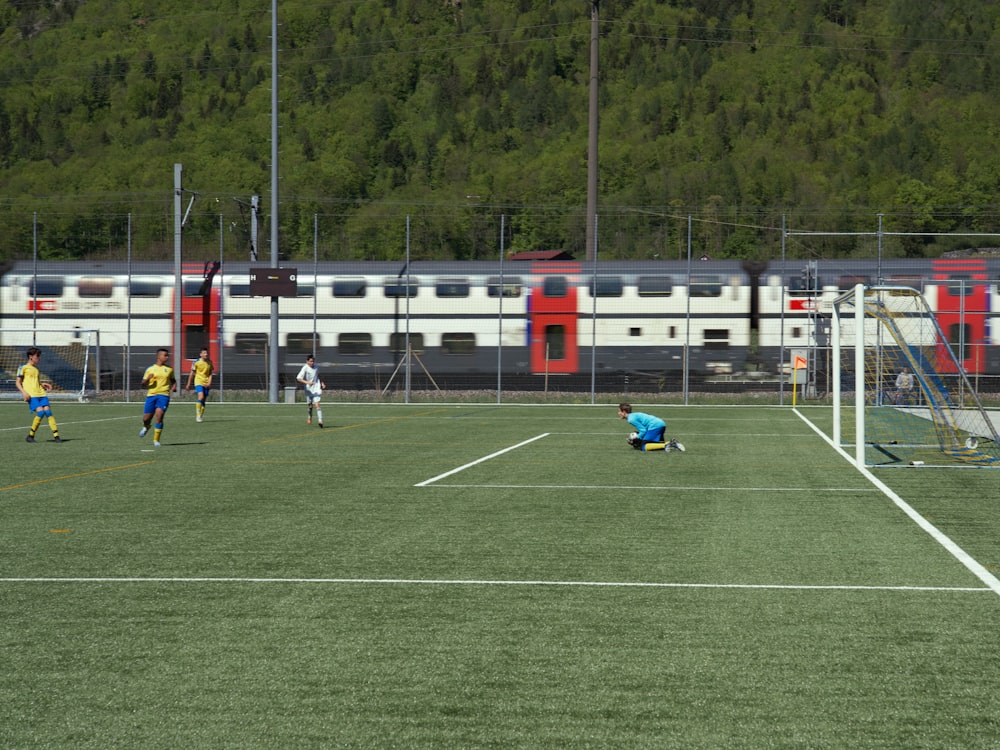 Eine Gruppe von Menschen, die auf einem Feld Fußball spielen