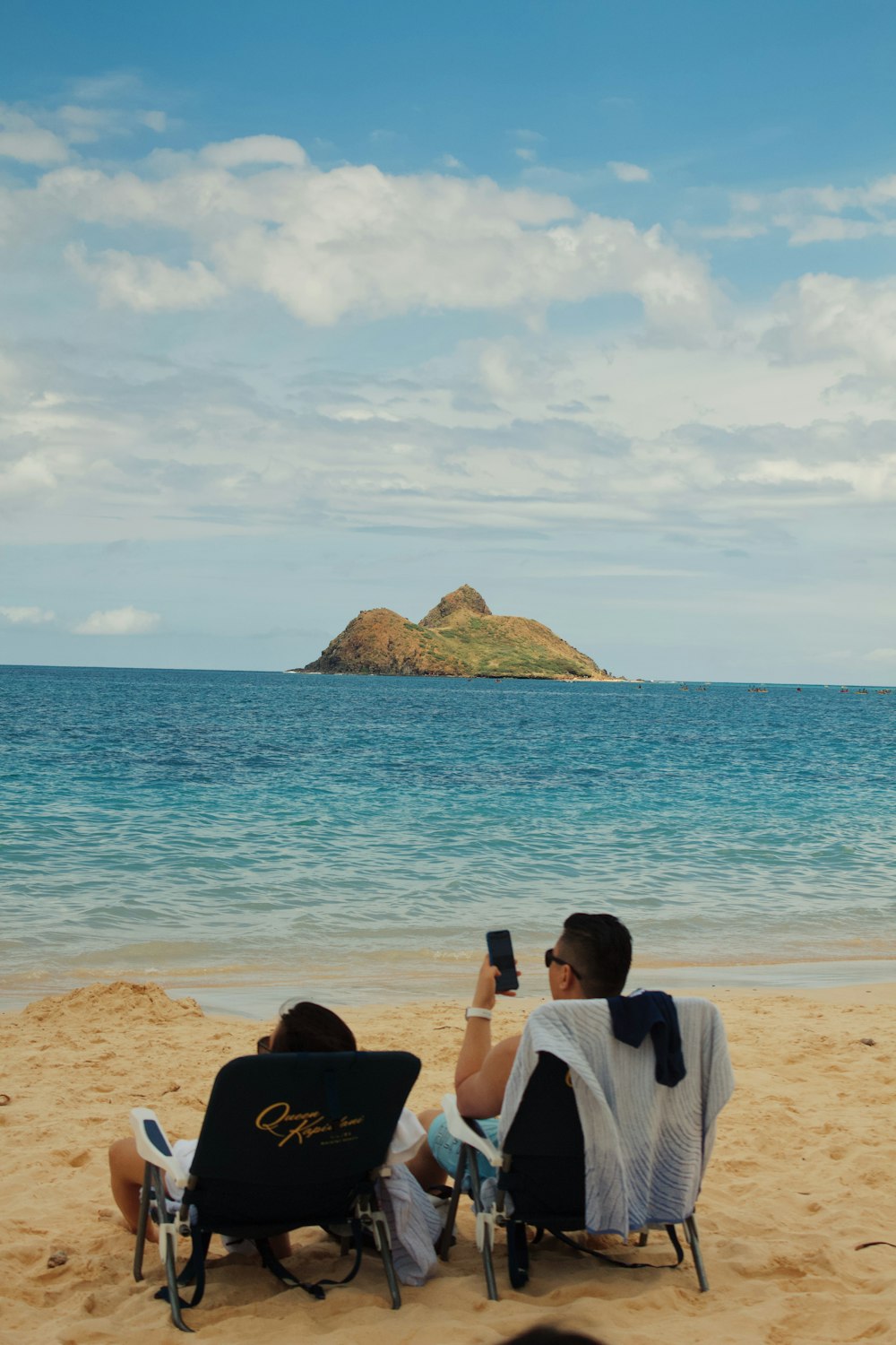 man and woman sitting on beach during daytime