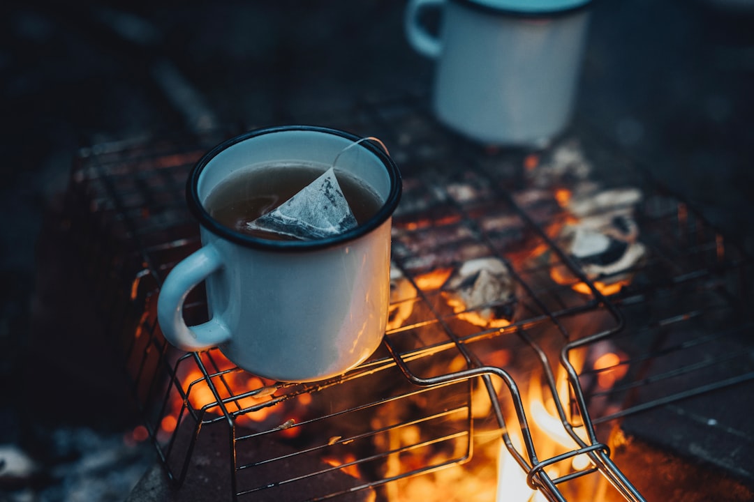 white ceramic mug on brown metal grill