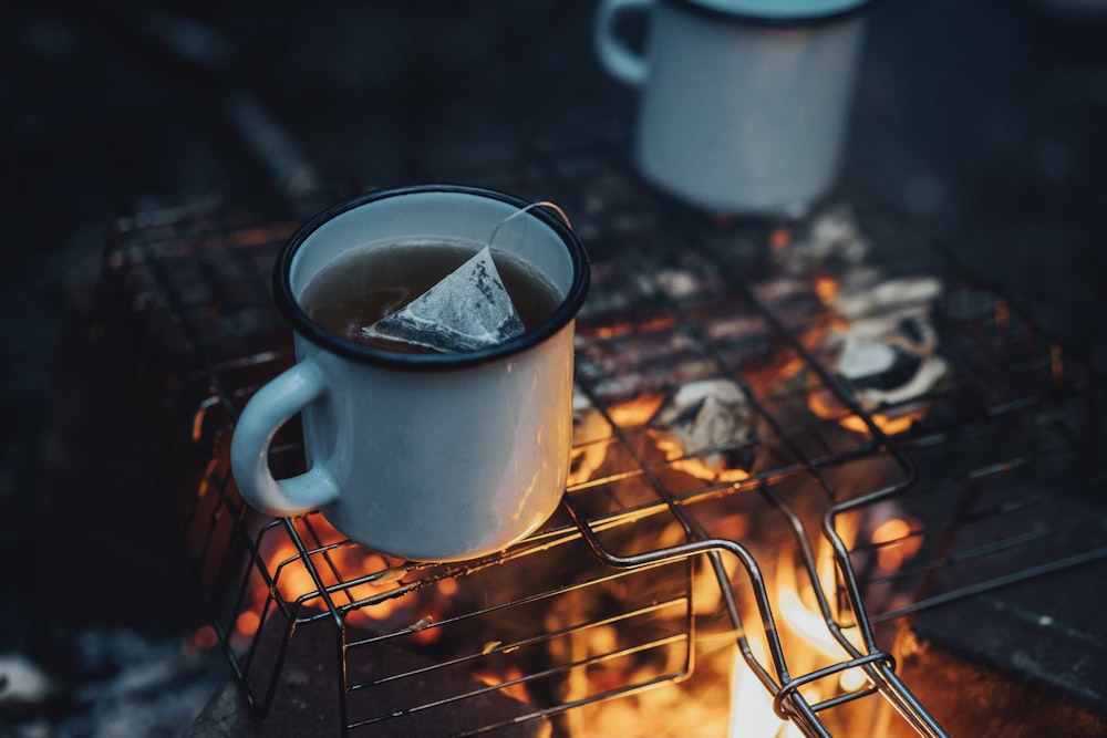 white ceramic mug on brown metal grill