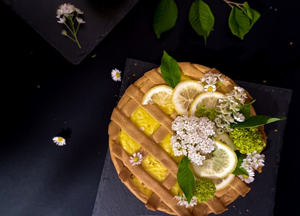 Close-up of a beautifully decorated lemon tart with a golden crust on a rustic wooden table