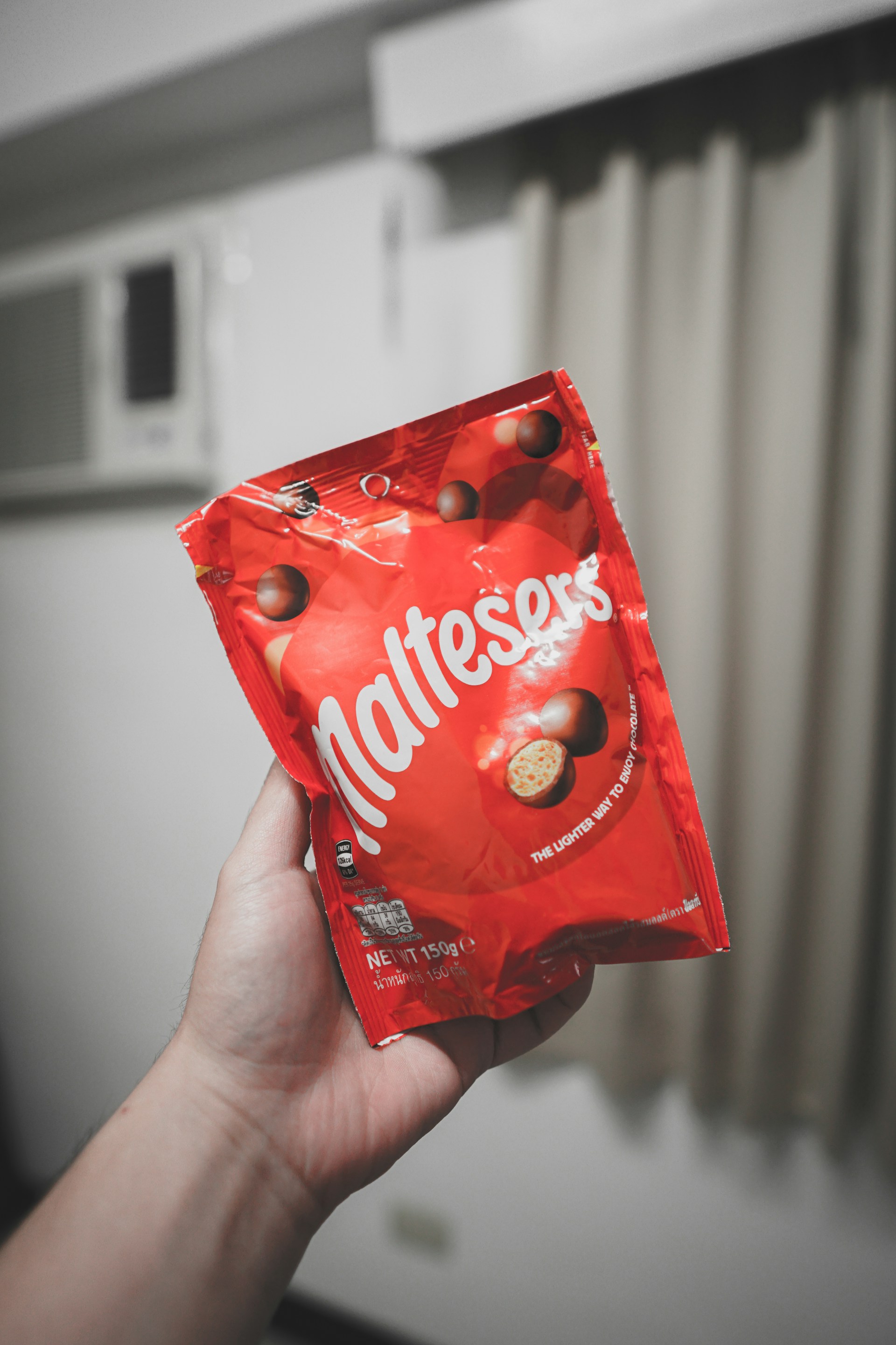 person holding red and white plastic pack