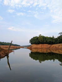 A serene water body surrounded by lush greenery symbolizing groundwater recharge.